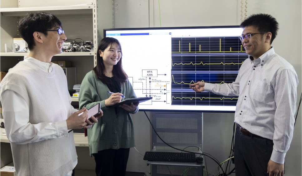 図3：病理動態を数理モデルで表現し、システム科学的アプローチによる新たな治療戦略を学生と一緒に検討している。